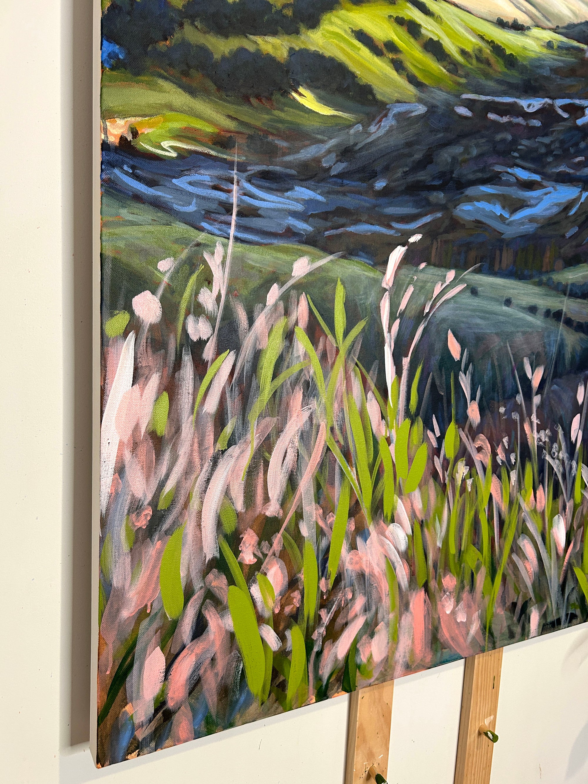 Painting of a natural landscape with grass, flowers, and water.